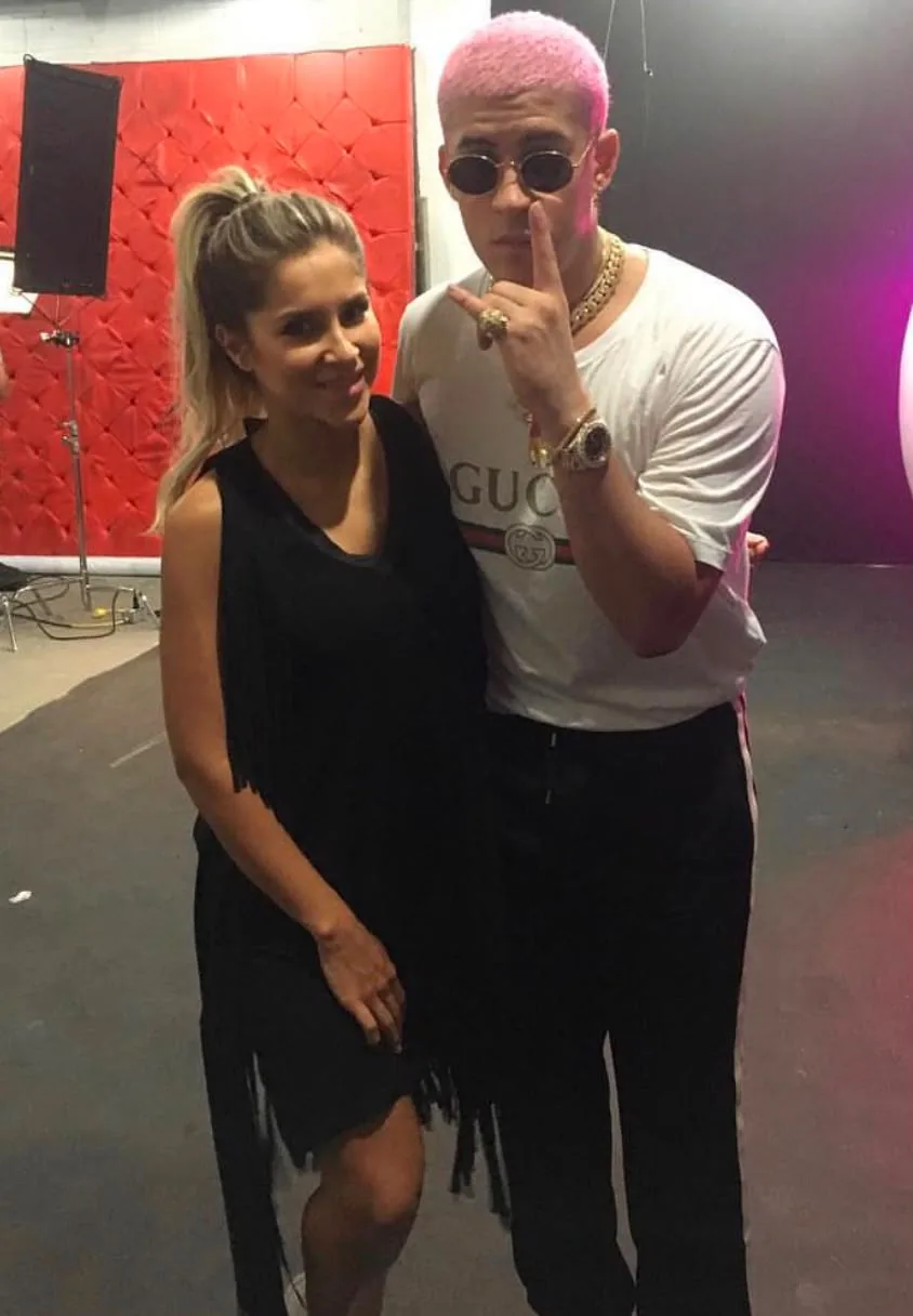 Moni Aristi junto a un artista de cabello rosado en el set