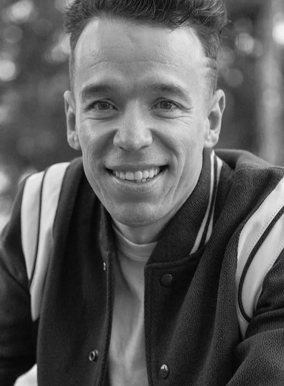 Retrato en blanco y negro de un artista con chaqueta varsity