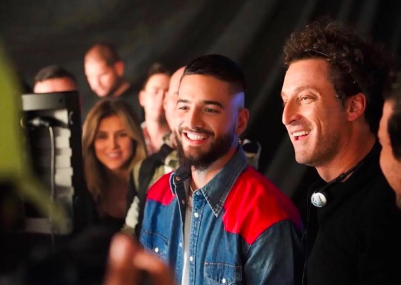 Artista sonriendo junto al equipo de producción frente al monitor