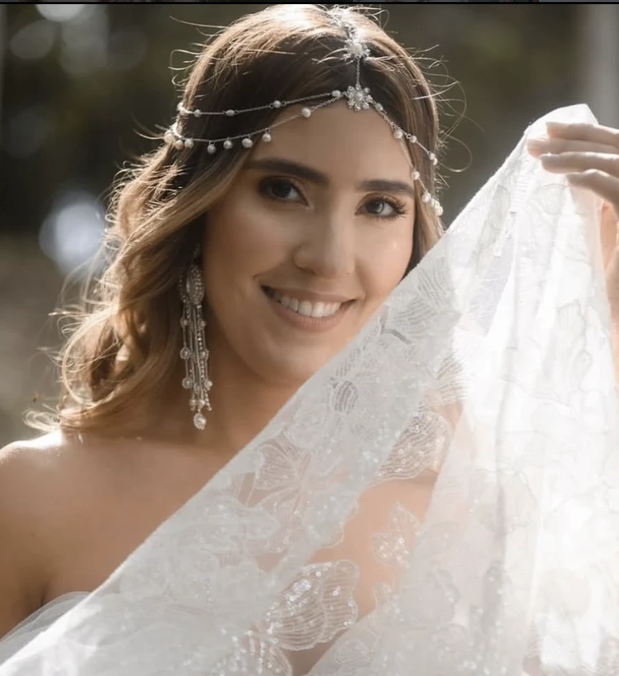 Novia sonriendo bajo el velo, retrato con luz natural a contraluz