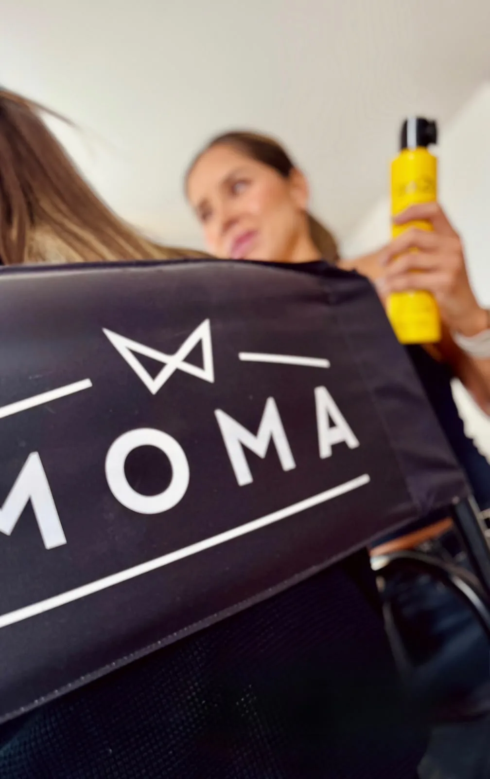 Backstage de MOMA: silla de maquillaje de la marca y fijador de cabello durante la preparación
